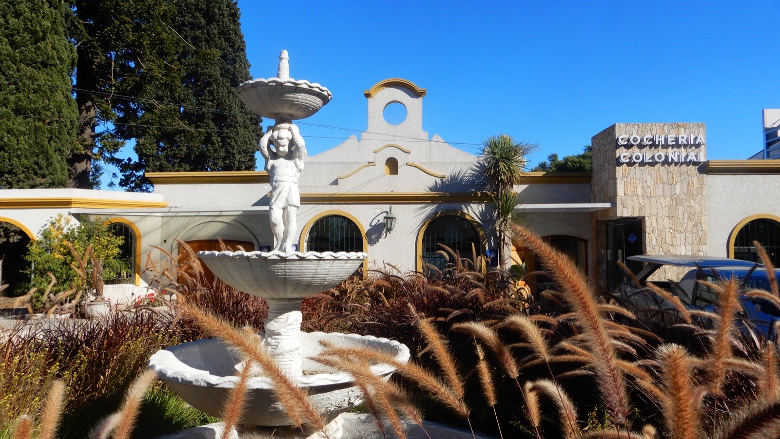 Frente de Cochería Colonial con la fuente y el jardín